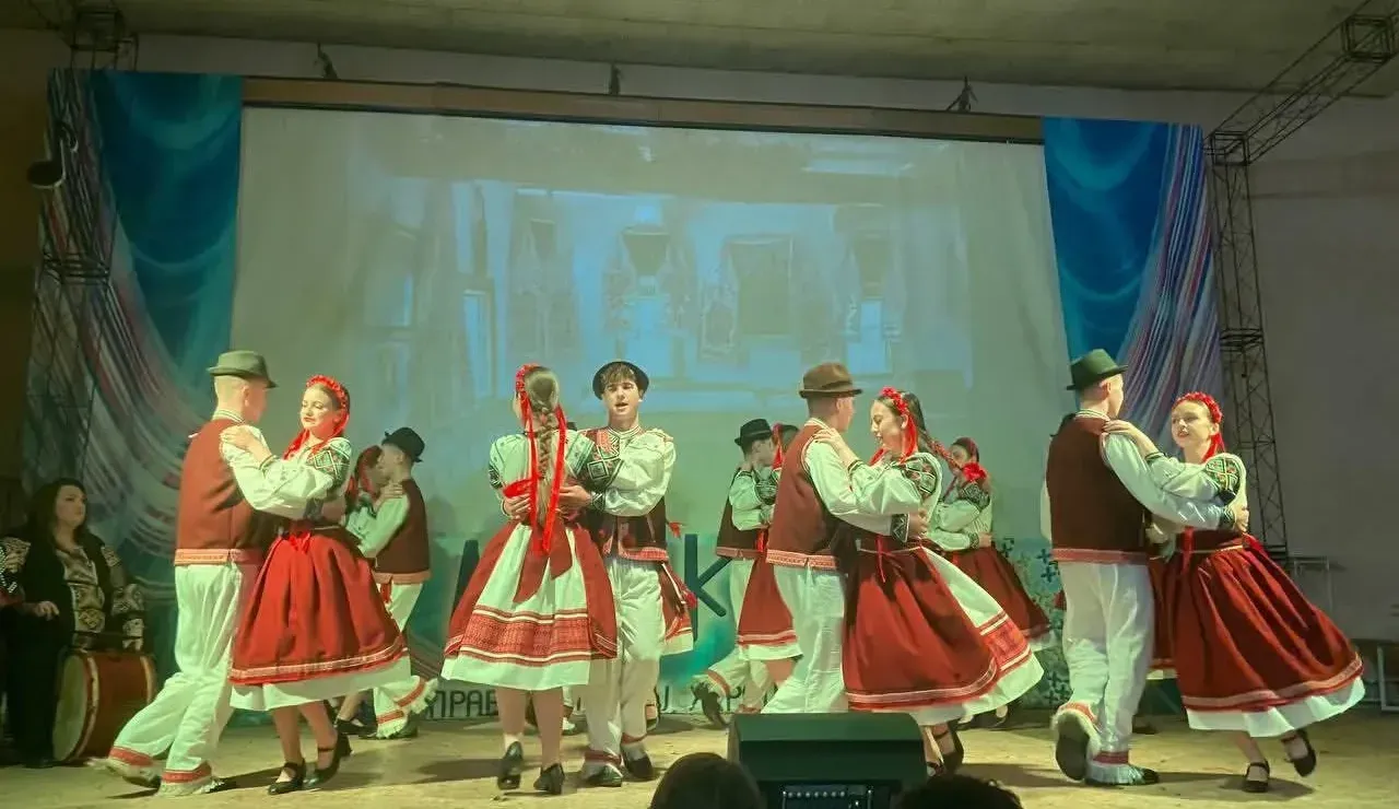 Учні ліцею в народних строях танцюють на сцені